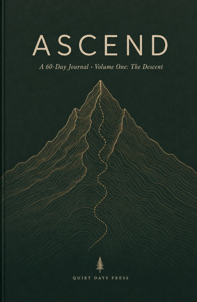 Ascend Volume One paperback cover: the word ASCEND in letterspaced brass serif capitals on a deep forest-green field, above a brass line-drawn mountain with a dotted trail climbing to the summit, the line &lsquo;A 60-Day Journal · Volume One: The Descent&rsquo;, a small fir-tree glyph, and the Quiet Days Press imprint at the foot.